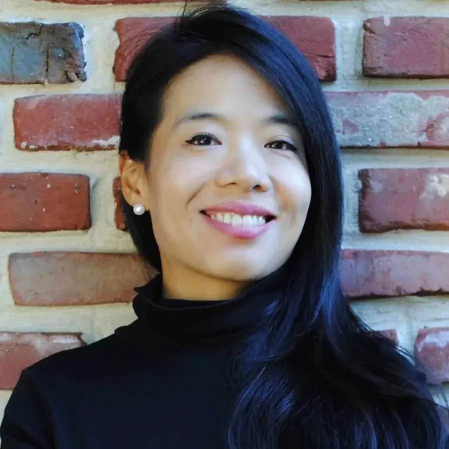 Portrait of Dr. Hannah Park in a black turtleneck in front of a brick wall