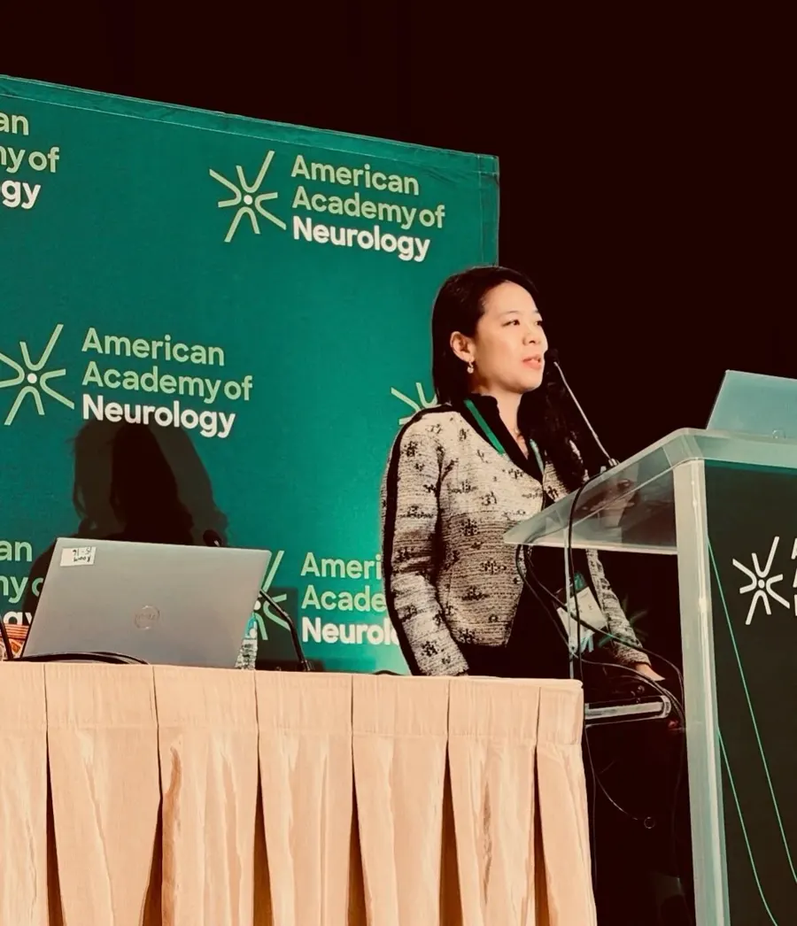 Dr. Park speaking at a podium at an American Academy of Neurology meeting