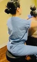 Dr. Park in scrubs giving a seated patient an injection treatment at the back of the neck